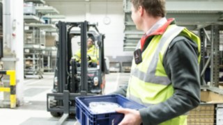 Person auf dem Firmengelände mit einer Portable Unit am Körper.
