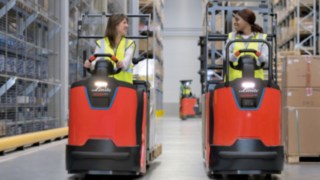 Zwei Mitarbeiterinnen fahren im Lager mit Kommissionierern der N20 Serie von Linde Material Handling.