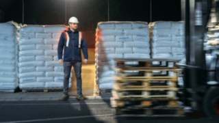 Mit dem Fußgängerwarngurt von Linde Material Handling gut sichtbar, wenn es darauf ankommt Lagerarbeiter und Stapler kreuzen sich und der Lagerarbeiter ist mit dem Fußgängerwarngurt von Linde Material Handling gut sichtbar