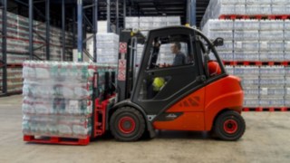 Ein gemieteter V-Stapler von Linde transportiert eine Palette mit Wasserkästen bei Agua Mineral im Lager