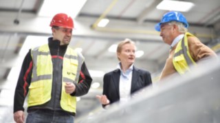 Linde Mitarbeiterin im Gespräch mit Kollegen in der Produktion