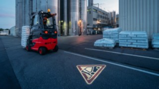 Zum umfassenden Angebot an Sicherheitsfeatures auf der Fachmesse A+A gehört der Linde TruckSpot. Per LED-Technik wird ein rotes Warndreieck auf den Boden projiziert und macht Fußgänger oder andere Staplerfahrer sehr deutlich aufeinander aufmerksam. 