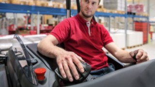 Mitarbeiter legt seine Hand auf den Multifunktionshebel von Linde Material Handling