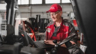 Techniker mit Laptop beim der Inspektion eines Staplers zur Aufbereitung